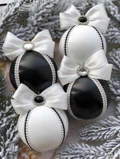 three black and white ornaments with bows on them