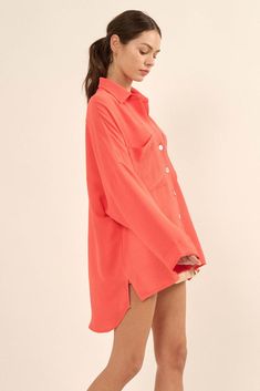 Solid, textured crepe shirt. Collared V neckline. Button-front closure with large, pearly shell buttons. Two chest pockets. Long sleeves with folded cuffs. Drop shoulder. High-low shirttail hem. Pleated yoke back. Oversized fit. 100% Polyester. Imported. Designed in LA. Model wears size S. Chic Blouse With Buttoned Pockets For Day Out, Spring Shirt With Buttoned Pockets, Spring Shirt With Buttoned Pockets In Solid Color, Trendy Daywear Blouse With Pockets, Red Collared Blouse With Pockets, Collared Blouse With Buttoned Pockets For Daywear, Spring Blouse With Lapel Collar In Solid Color, Solid Color Button-up Blouse With Buttoned Pockets, Solid Button-up Blouse With Buttoned Pockets