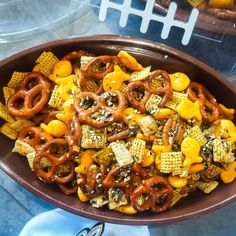 a bowl filled with cheetos and pretzels on top of a table