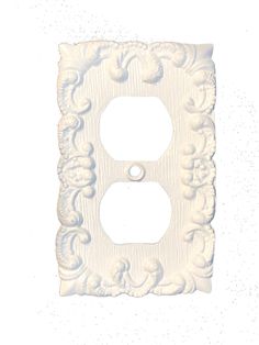 a white light switch cover with an ornate design