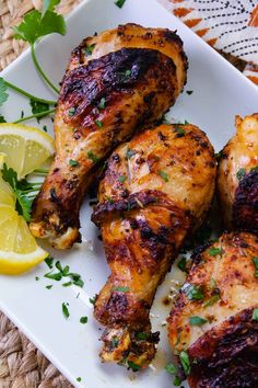 grilled chicken with lemon and parsley on a white plate