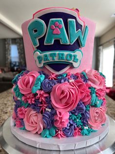 a birthday cake decorated with pink, blue and purple flowers