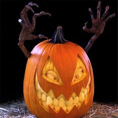 a carved pumpkin sitting on top of hay