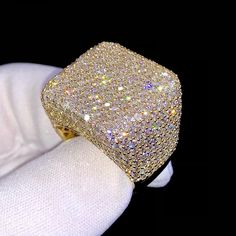 a person wearing a white glove with a gold ring on top of their hand,