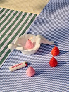 small crocheted birds sitting on top of a blue and white striped table cloth