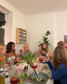 a group of women sitting around a table eating food