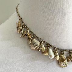 Vintage seashell costume jewelry necklace.  Perfect accessory for your European seaside getaway.  Made from non precious metal. Circle clasp at back. 16 inches Shell Charms Jewelry, Vintage Gold Jewelry For The Beach, Shell Necklace For Jewelry Making, Vintage Gold Jewelry For Beach, Gold Coastal Necklace With Shell Shape, Vintage Gold Necklace For Beach, Gold Shell Necklace In Coastal Style, Beach Shell Charms Jewelry, Gold Coastal Style Shell Necklace