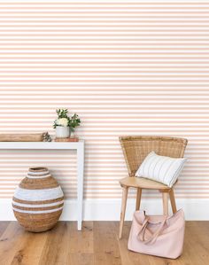 a white table and chair in front of a wall with vertical stripes on the wall