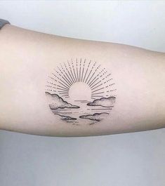 a person's arm with a tattoo on it that has the sun and clouds