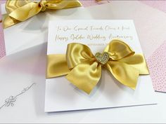 a close up of a greeting card with a gold bow on the front and side