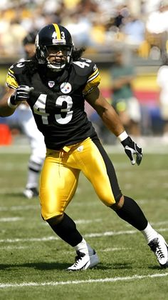 a football player running with the ball in his hand and wearing a helmet on one knee