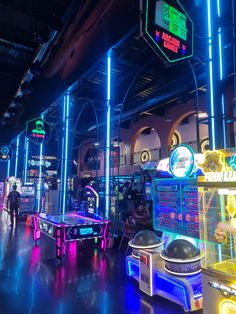 the arcade is lit up with neon lights and features several different types of machines for playing games