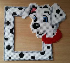 a dalmatian dog made out of legos on a wooden table with a red heart