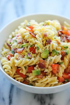 a white bowl filled with pasta and vegetables