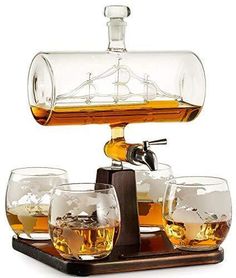 an old fashioned whiskey dispenser with four glasses