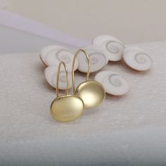 Fine minimalist 14k gold earrings with a highly shiny finish. They are handmade of yellow 14k solid gold, and are comfortable to wear. These drop earrings are chic and eye catching.  You will enjoy wearing them all day long as they look great with any style, casual or dressy. A wonderful gift for yourself or for someone you love. Total length of the earrings: ~22 mm = ~0.87 inch Oval's width: approx. 13.5 mm = approx. 0.53 inch Oval's height: approx. 10.5 mm = approx. 0.4 inch Oval's thickness is approx. 2.4 mm = approx. 0.09 inch * The earrings will be packed in a gift box ready to give as a gift, and shipped via Express mail service which usually takes 4-6 business days to arrive. * For more gold earrings click here: http://www.etsy.com/il-en/shop/SigalGerson?section_id=13604349&ref=shop Fine Gold Jewelry, Oval Earrings, Oval Earring, Unique Gifts For Her, Earrings Minimalist, Gold Drop Earrings, Jewelry Unique, Minimalist Earrings, Jewelry Earrings Dangle