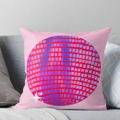 a pink and blue throw pillow on a couch