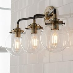 a bathroom light with five bulbs hanging from it's arm and three lights on the wall