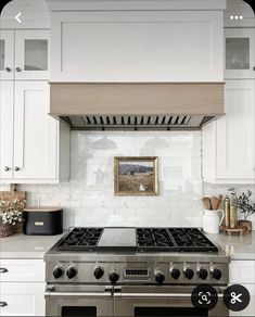 a stove top oven sitting inside of a kitchen next to white cabinets and counter tops