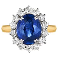 an oval blue sapphire and diamond cluster ring in 18ct yellow gold with white diamonds