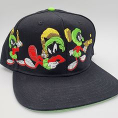 a black hat with an image of marvin the martian and other cartoon characters on it