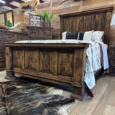 a large bed sitting on top of a hard wood floor next to a wooden dresser