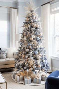 a decorated christmas tree in the corner of a living room with blue and white decor