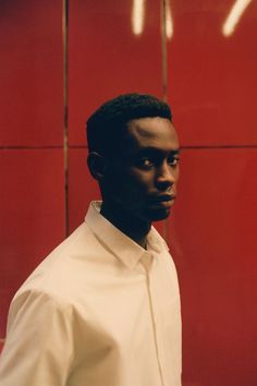 a man standing in front of a red wall