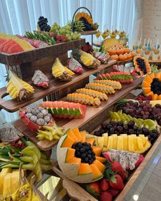 an assortment of fruits and cheeses displayed on wooden trays