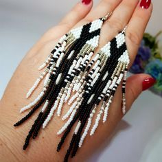 a woman's hand with black and white beaded bracelets