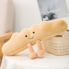 a stuffed toy is sitting on a bed next to a basket with a smiling face