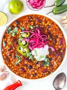 a white bowl filled with beans, onions and cilantro on top of a table