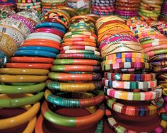 many different colored bangles are stacked on top of each other in the market place