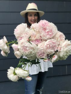 a woman holding a bouquet of pink and white flowers