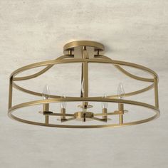 a ceiling light with three lights on it and a white wall in the back ground