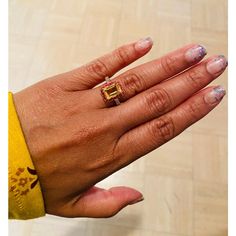 a woman's hand with two rings on top of her left and the other half of her right hand