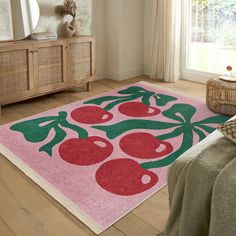 a pink rug with cherries on it in a room next to a dresser and window