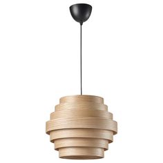 a wooden light fixture with a black lamp on the top and an object hanging from it's side