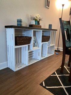 a dining room table with baskets on top of it next to a wall mounted shelf