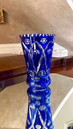 a blue glass vase sitting on top of a table