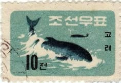 a postage stamp with an image of a whale in the water on it's side