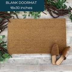 a pair of brown shoes sitting on top of a door mat next to green plants