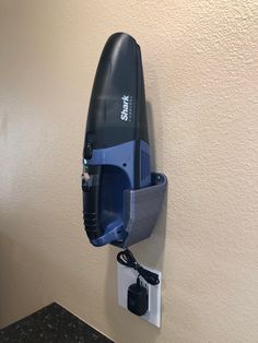 a hair dryer hanging on the wall next to a charger