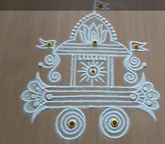 an intricate design made with white powder on wooden table top, in the shape of a chariot