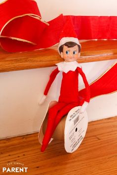 an elf sitting on top of a wooden shelf