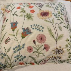 a white pillow with colorful flowers on it