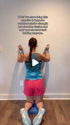 a woman sitting on top of a blue bench with her hands in the air while holding two dumbbells