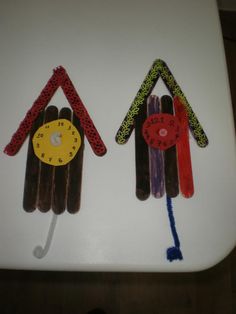 two birds made out of popsicle sticks on top of a white toilet seat with the lid up