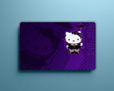 a purple hello kitty card sitting on top of a blue wall