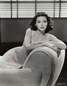 an old photo of a woman sitting on a couch